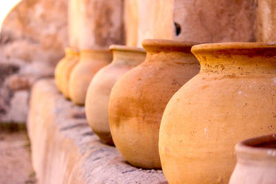 Clay pots in row by wall for sale at market