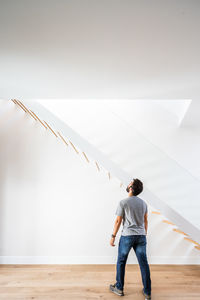 Rear view of man standing against wall