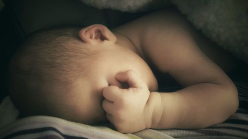 Close-up of baby sleeping on bed