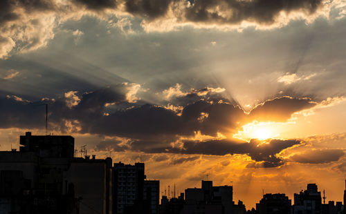 Silhouette buildings against sky during sunset