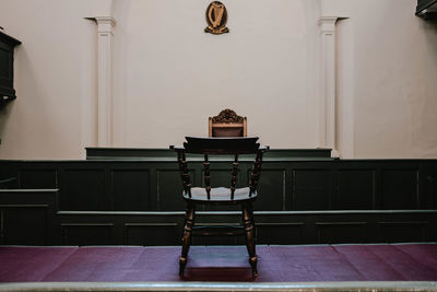 Empty chairs and table against wall at home