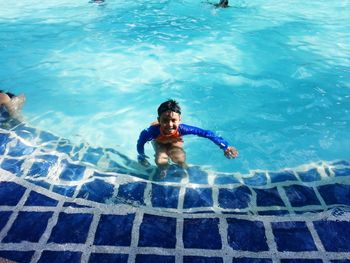 High angle view of happy boy enjoying in swimming pool