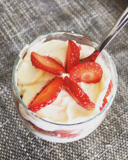 High angle view of dessert garnish with sliced strawberries served on table