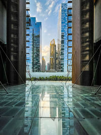 Reflection of modern buildings in swimming pool against sky