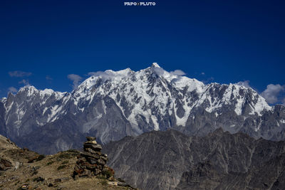 Scenic view of snowcapped mountains against blue sky