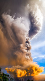 Smoke emitting from volcanic mountain against sky 