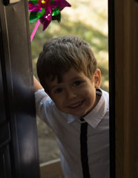 Portrait of cute smiling boy by door