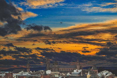 View of cityscape against cloudy sky