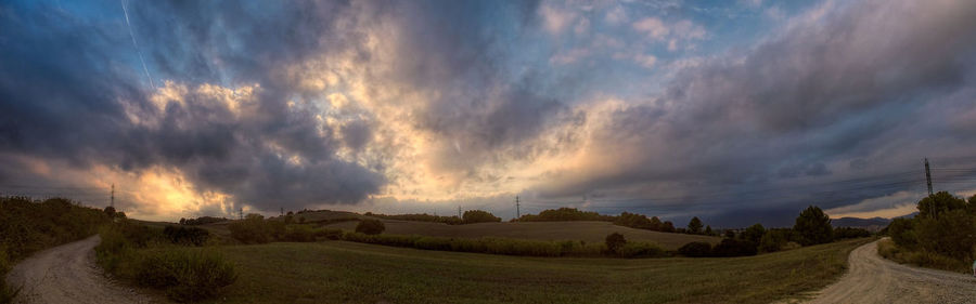 Scenic view of field against cloudy sky