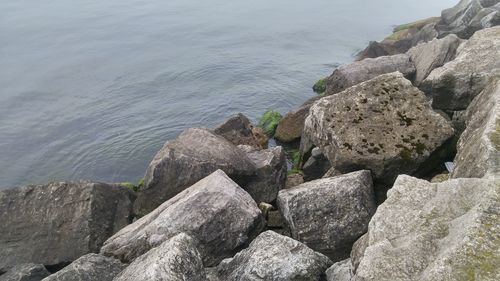Rocks by sea against sky
