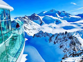 Scenic view of snowcapped mountains against blue sky