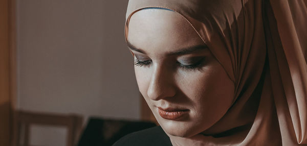 Close-up portrait of young woman at home