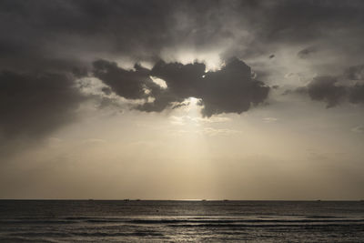 Sunlight streaming through clouds over sea