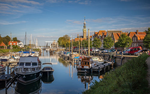 Boats moored in river against buildings in city