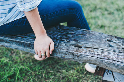 Low section of man sitting on wooden seat