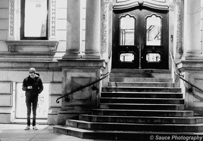 Full length of woman standing on staircase of building