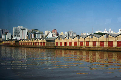 Houses in city against clear blue sky