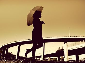 Low angle view of people on bridge against sky