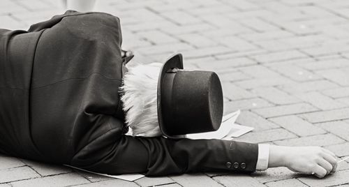 Close-up of mime lying on footpath