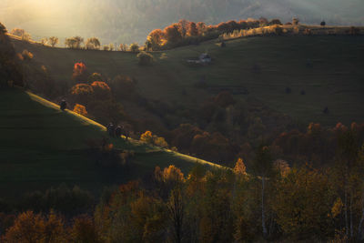 Scenic view of field by mountains against sky