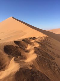 Scenic view of desert against clear blue sky