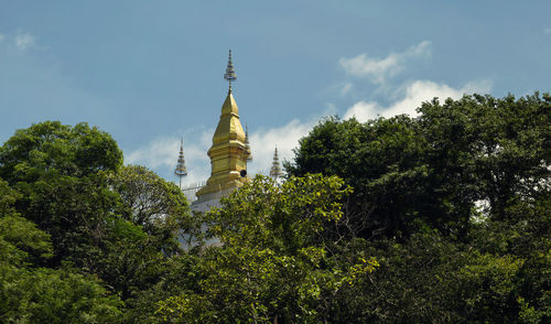 Low angle view of trees and building against sky