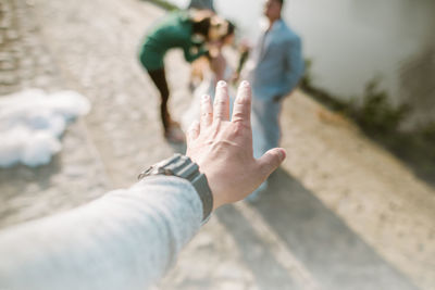 Cropped hand gesturing against people with bride