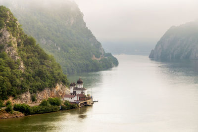 Scenic view of river by mountains against sky