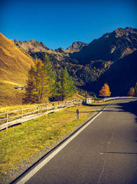 Empty road along landscape and mountains against sky