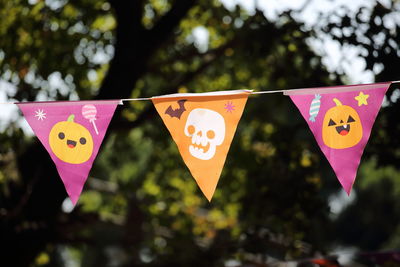 Close-up of multi colored flags hanging on tree