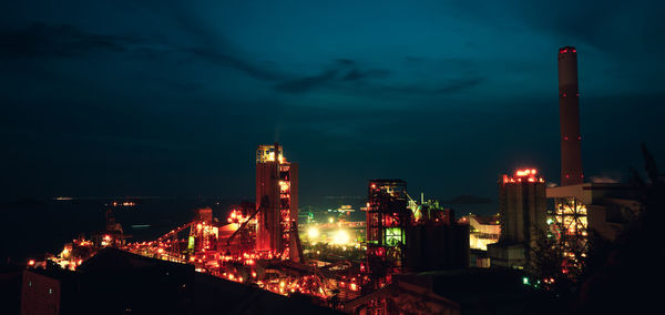 Illuminated buildings in city against sky at night