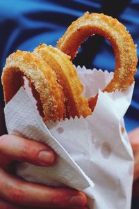 Close-up of hand holding fried food 