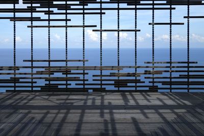 Sea seen through metal grate on pier