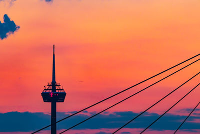 Low angle view of silhouette tower against orange sky