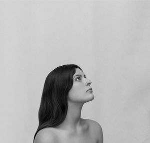 Young woman looking away in a white plain background 