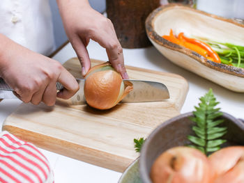 Midsection of woman preparing food on cutting board