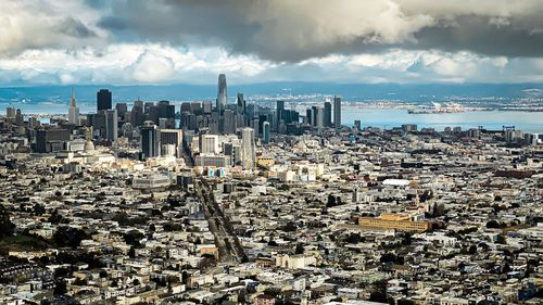 Aerial view of city against cloudy sky