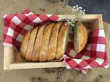 High angle view of fresh baked bread in wooden container on table