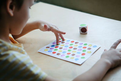 Child playing diy dot game for fingers. useful game for development of childs fingers