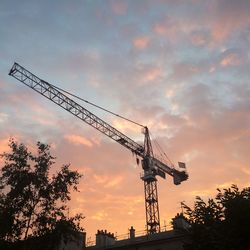 Low angle view of silhouette crane against sky during sunset