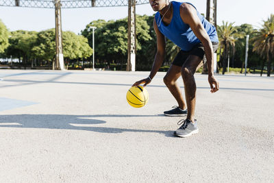 Male basketball player playing at sports court