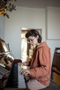 Side view of young woman sitting at home