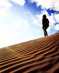 Low angle view of woman standing on beach against sky