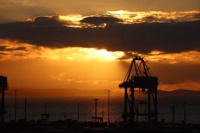 Silhouette sailboat in sea against sky during sunset