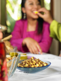 Cropped hand feeding woman at table during traditional festival