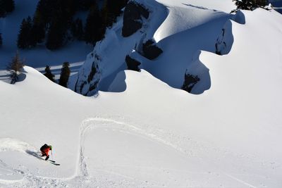 People skiing on snowcapped mountain during winter