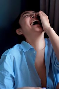 Close-up of young woman laughing at home