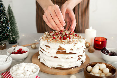 Preparing food for christmas dinner. women's hands decorated with berries homemade christmas cake 