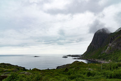 Scenic view of sea and mountains against cloudy sky