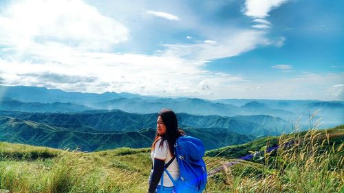 Woman standing on mountain against sky